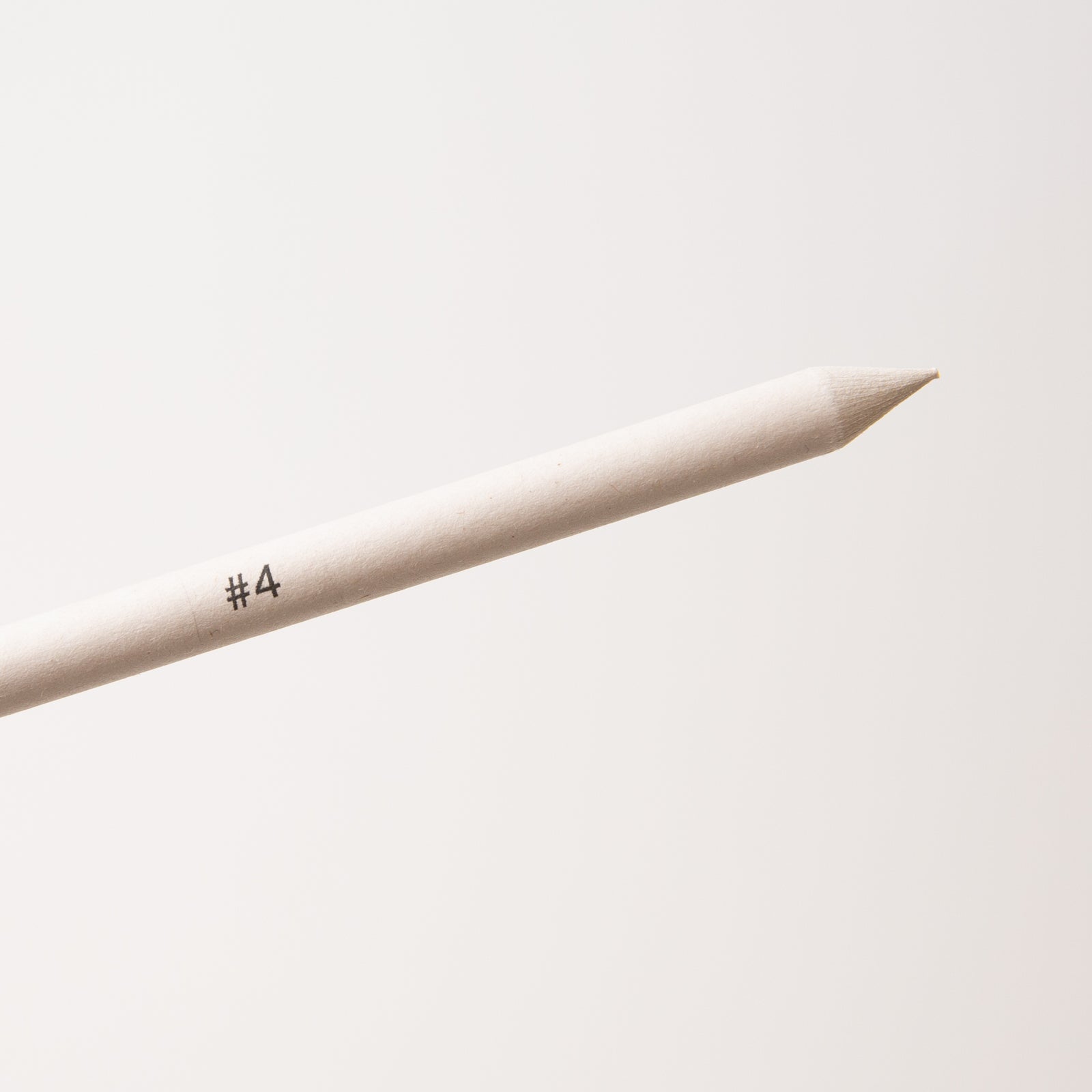 Close up of beige blender stick pencil with '#4' marking on a light gray background