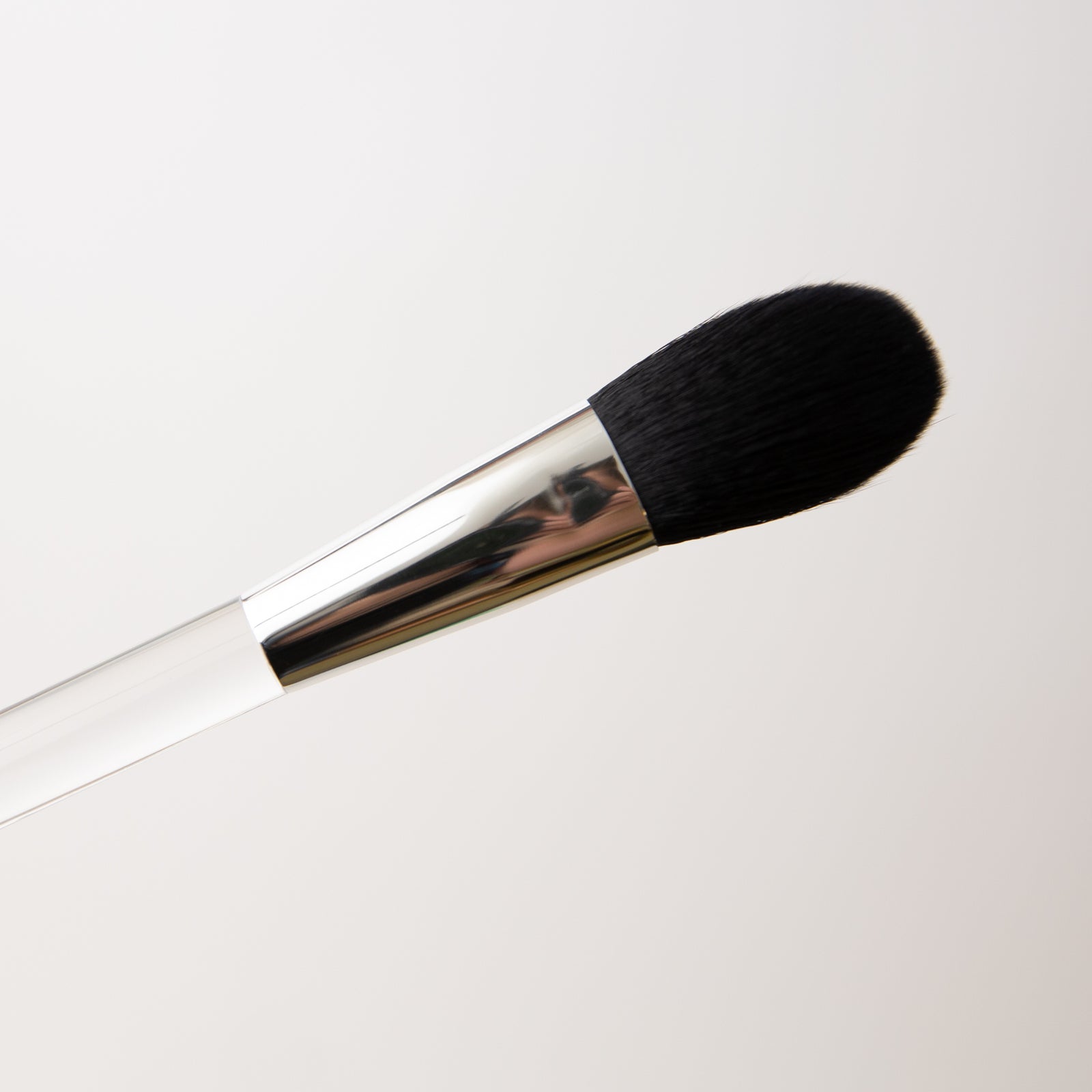 Makeup brush with black bristle head on a white background