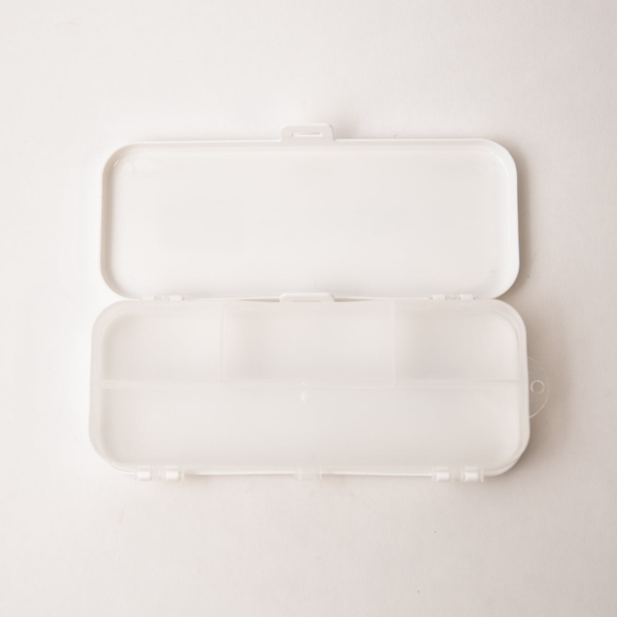 White rectangular case with a lid on a light beige background