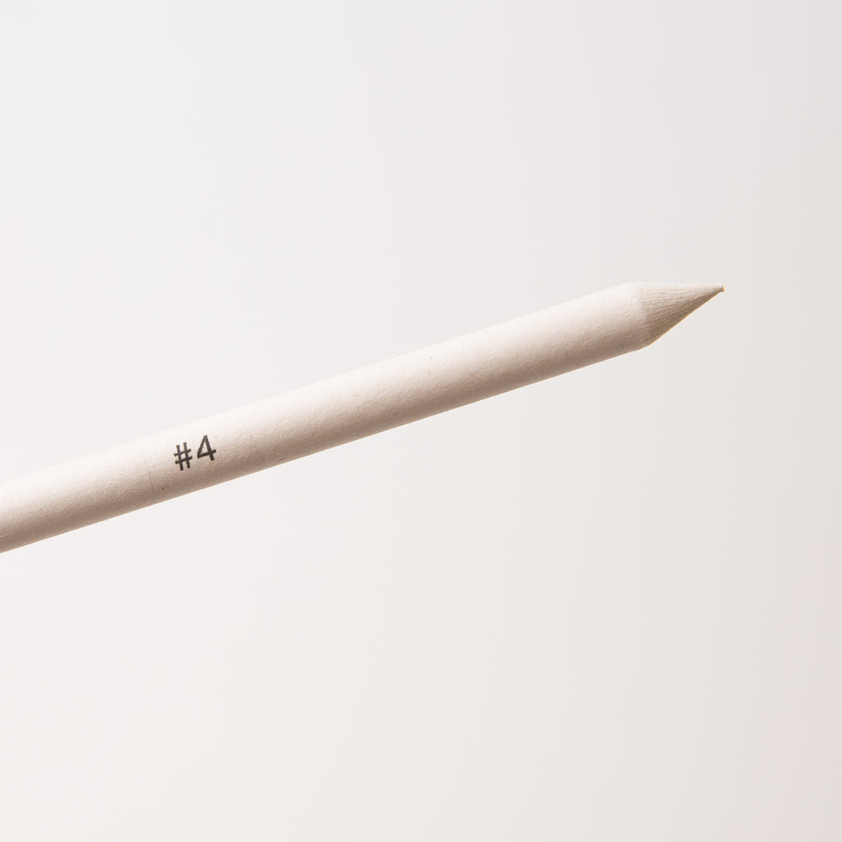Close up of beige blender stick pencil with '#4' marking on a light gray background